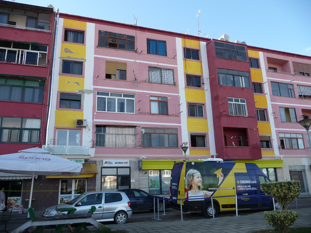 A colorful building with cars parked in front of itDescription automatically generated with low confidence